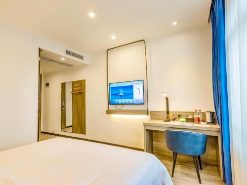 宜宾7天优品宜宾北门汽车站店的酒店客房设有一张床、一张书桌和一台电视机。