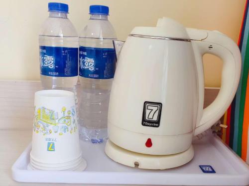 沁县7天酒店·长治沁县店的放在架子上的搅拌机,装有瓶装水