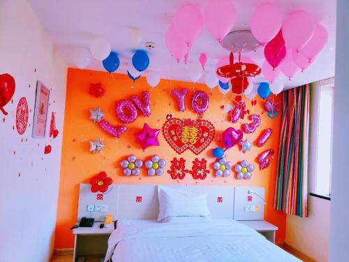 沁县7天酒店·长治沁县店的卧室配有带气球的床,墙上有心