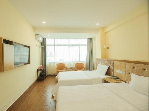 三亚7天酒店三亚亚龙湾景区店的酒店客房设有两张床和窗户。