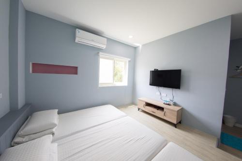 小琉球岛自由空间的一间卧室配有一张床和一台平面电视