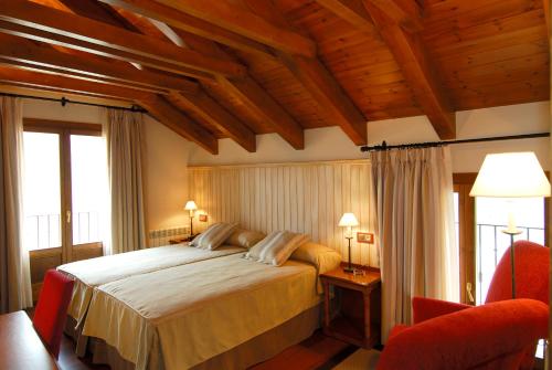 卡斯特洪德索斯蒂亚莫酒店的一间卧室配有一张大床和一张红色椅子