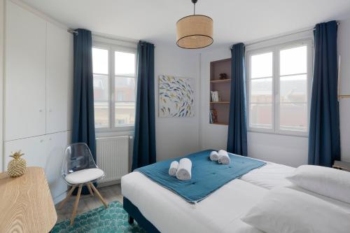 圣马洛Cap à l'Ouest by Cocoonr的一间卧室配有一张带蓝色窗帘的床和一把椅子
