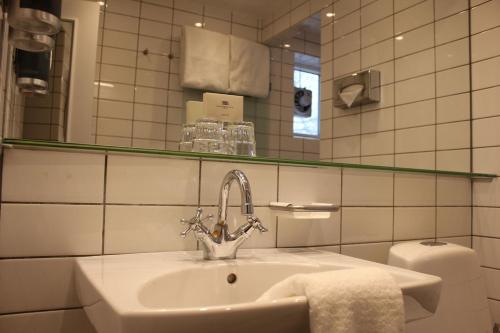 夏洛滕隆斯库舒韦德酒店的一间带水槽、镜子和卫生间的浴室