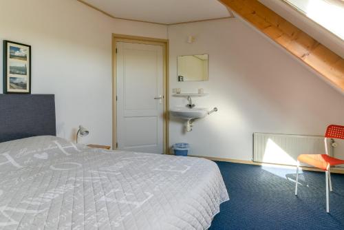 Baaiduinenvakantiehuis op terschelling的一间卧室配有床和水槽