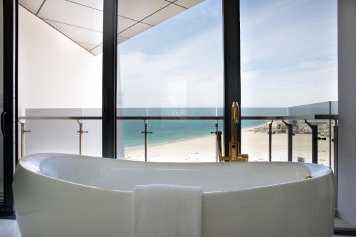 阿布扎比Jumeirah Saadiyat Island Abu Dhabi的带浴缸的浴室,享有海滩美景