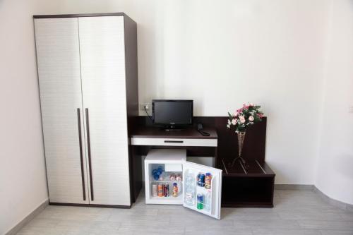 米兰HOTEL Poma的客房设有冰箱和带电视的书桌。