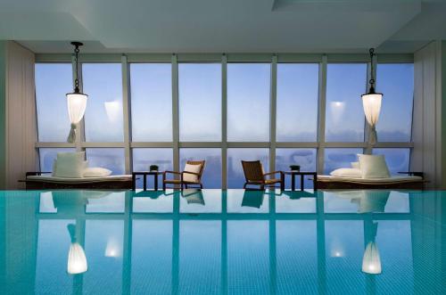 上海上海柏悦酒店的酒店客房设有带椅子的游泳池和窗户。