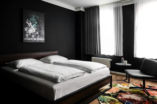 莱比锡GRONERS Leipzig的一间黑色卧室,配有一张床和一把椅子