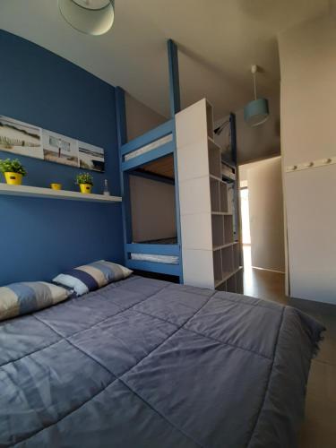 圣让-德蒙CLOS DE L'OCEAN 2 - maison 3 chambres à 300 m de la plage的一间卧室设有一张床和蓝色的墙壁