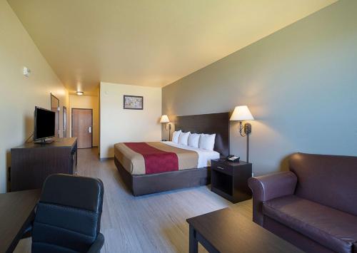 布里奇波特Econo Lodge Inn & Suites Bridgeport的酒店客房,配有床和沙发