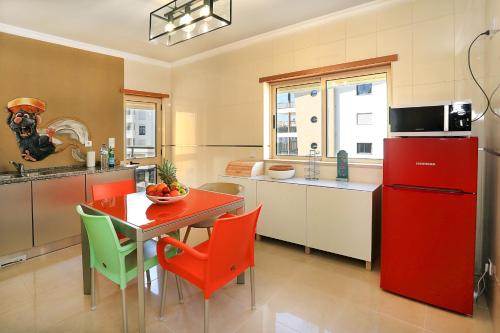 拉戈斯HENRI'S APARTMENTS - Pátio do Convento的厨房配有红色冰箱和桌椅
