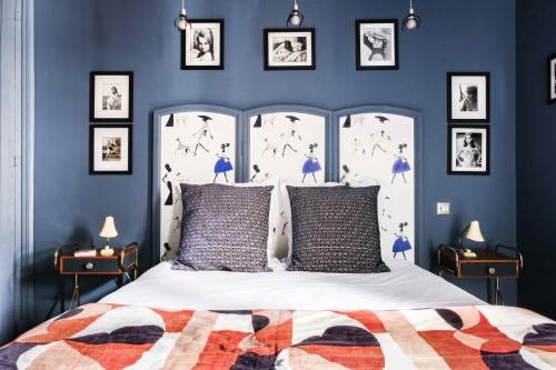 索姆河畔的圣瓦列里拉菲姆科特迪瓦酒店的卧室拥有蓝色的墙壁,配有一张带枕头的白色床。