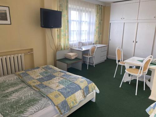 Tytuvėnai萨马纳汽车旅馆的一间卧室配有一张床、一张桌子和一张书桌