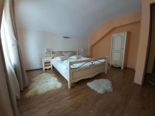 普雷代亚尔Vila Piscul Ursului的卧室配有白色的床,铺有木地板