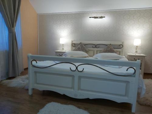 普雷代亚尔Vila Piscul Ursului的一间卧室配有一张白色床和两盏灯。