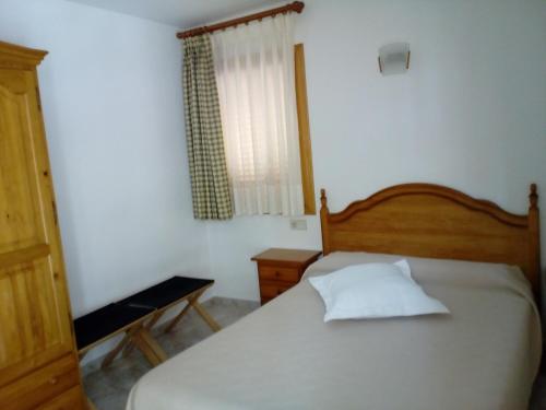 格劳斯Hostal Lopez的卧室配有床、椅子和窗户。