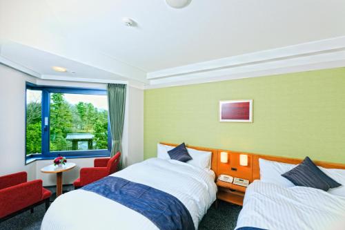 京都京都花园皇宫酒店的酒店客房设有两张床和窗户。