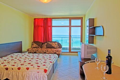 索佐波尔黑海乐园酒店的一间卧室配有一张床、一张沙发和一个窗口