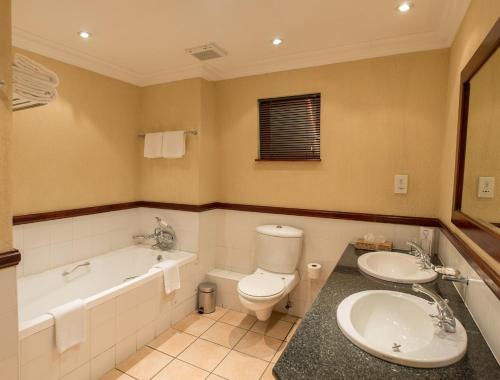 哈博罗内皮蒙特莫迪尔酒店的带浴缸、卫生间和盥洗盆的浴室