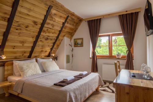 普利特维采湖普里特维采乡村小屋住宿加早餐旅馆的一间卧室设有一张床和木制天花板