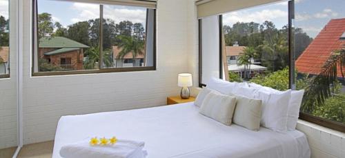 拜伦湾主海滩公寓 的配有大窗户的客房内的白色床