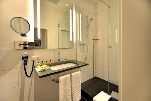 埃施韦格蓬维瑟拉别墅酒店的浴室配有盥洗盆和带镜子的淋浴