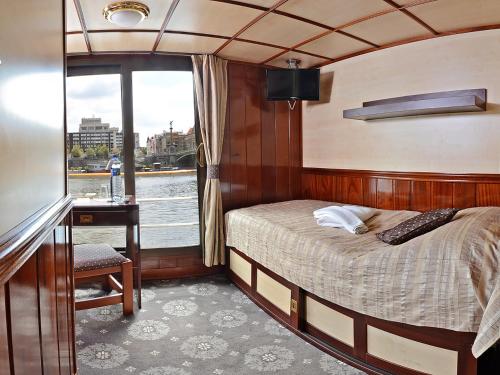 利托梅日采Florentina boat的船上的卧室,配有一张床和一张书桌