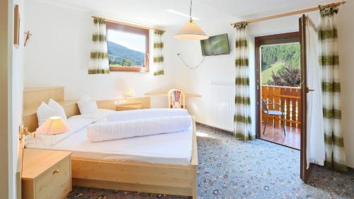 科莱伊萨尔科Pension Alpenhof B&B的一间带大床的卧室和一个阳台