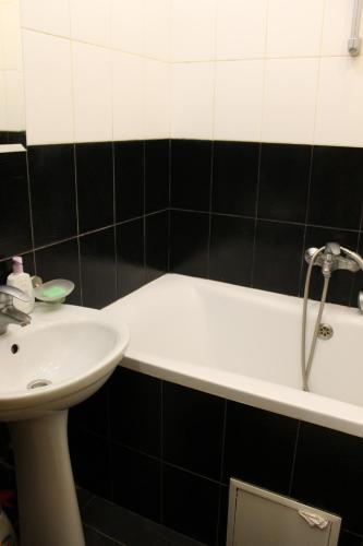 切尔尼戈夫Квартира-студия的浴室配有盥洗盆和浴缸。