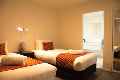 特卡波湖Tekapo Luxury Apartments的一间卧室设有两张床和窗户。