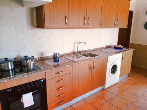 拉戈斯金塔多斯卡拉克丝酒店的厨房配有水槽和洗衣机