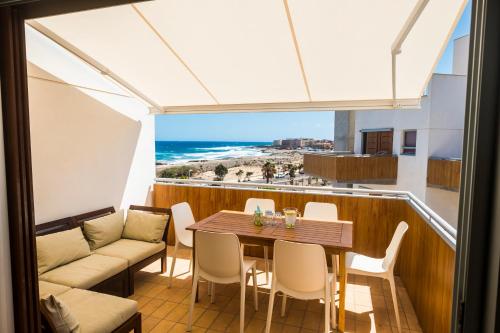 厄尔梅达诺Viviendamedano的一个带桌椅和海滩的阳台