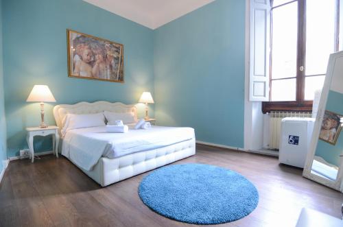 佛罗伦萨Speziali - Deluxe 2 bedroom flat nearby Piazza Repubblica的蓝色的卧室配有白色的床和蓝色地毯