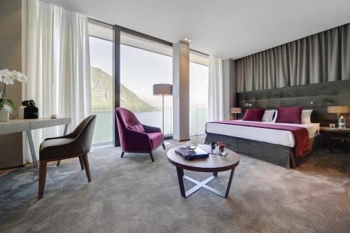 坎皮奥内Grand Hotel Campione的酒店客房带一张床、一张桌子和椅子