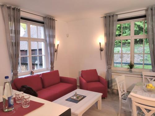 BielatalFerienwohnung Bastei的客厅配有红色的沙发和桌子