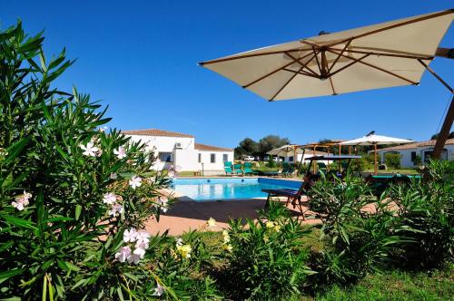 巴里萨尔多拜亚塞酒店的游泳池配有太阳伞、椅子和桌子