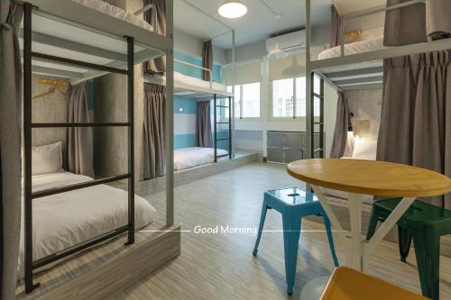 花莲市花莲北吉光轻旅青年旅馆的客房设有两张双层床和一张桌子。