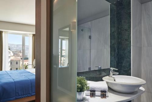 雅典雅典阿利昂酒店的一间带水槽的浴室和一间配有床铺的浴室