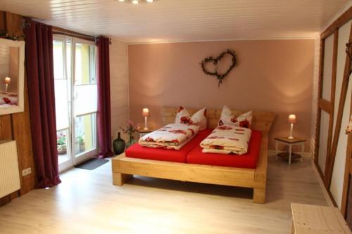 费茨肖Inas Spreewaldstube的卧室配有一张红色床单,墙上有心