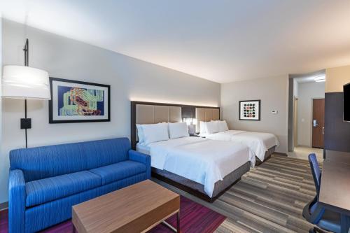 柏塞尔Holiday Inn Express & Suites Purcell, an IHG Hotel的酒店客房,设有两张床和一张蓝色的沙发