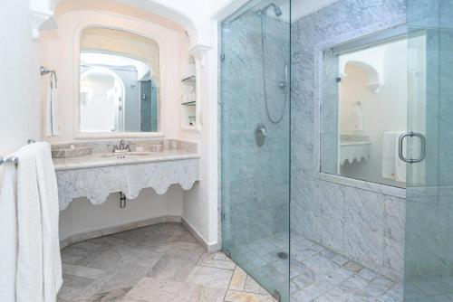 曼萨尼约哈达布里萨斯酒店的一间带玻璃淋浴和水槽的浴室