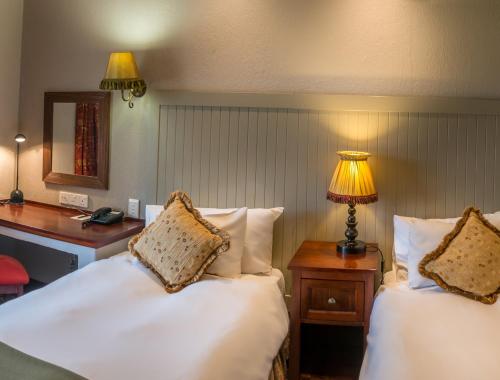 伯利恒边疆皮尔蒙特米特库尔特酒店，伯利恒的一间卧室配有两张床、一张桌子和一盏灯。