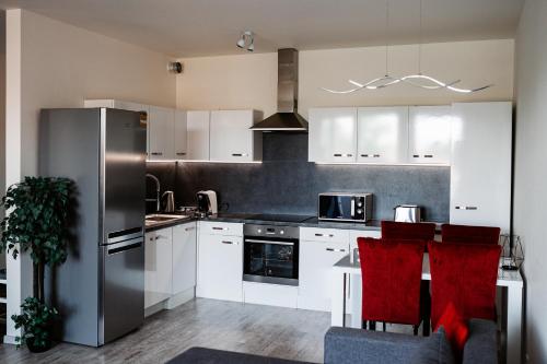 科希策AH Radnica的厨房配有白色橱柜和不锈钢冰箱