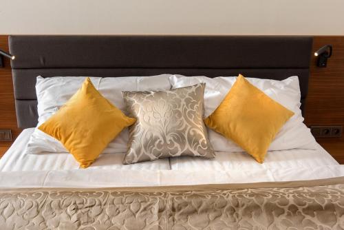 伏尔塔瓦河畔赫卢博卡Residence Hluboká的一张带四个枕头和黑色床头板的床