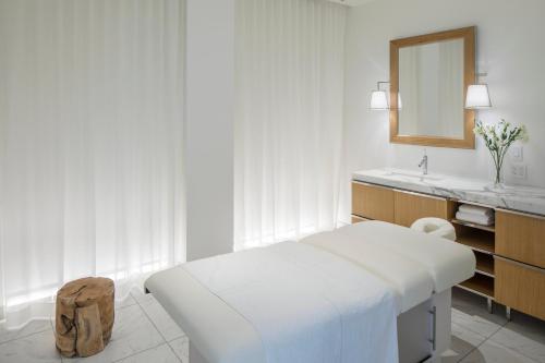 西雅图Lotte Hotel Seattle的白色卧室配有床和镜子