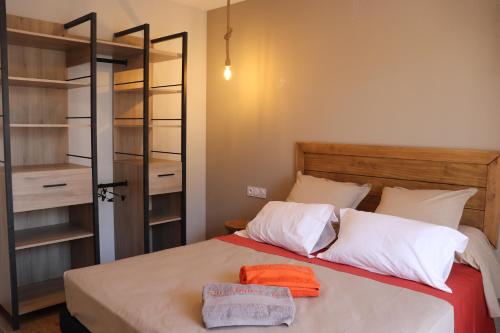 MontpeyrouxGite Aigues Vives的一间卧室配有一张带白色枕头的床和一个衣柜。