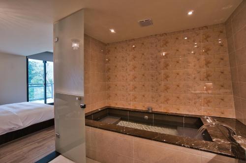 鱼池乡太和日月旅馆的一间位于客房角落的带浴缸的浴室