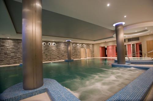 科克瑞维尔李酒店 - 多伊尔酒店集团的带有柱子的酒店客房内的游泳池