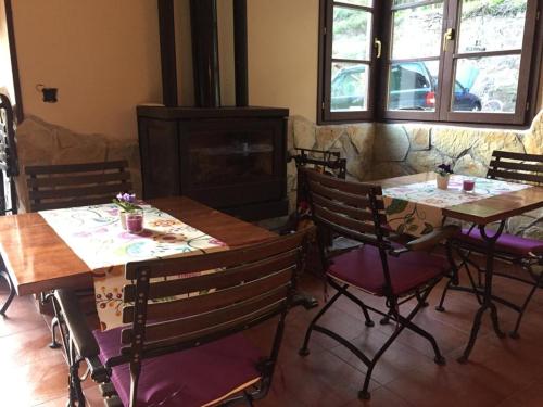 Santa EulaliaHotel peñacabrera 1的一间带2张桌子和椅子的用餐室以及壁炉